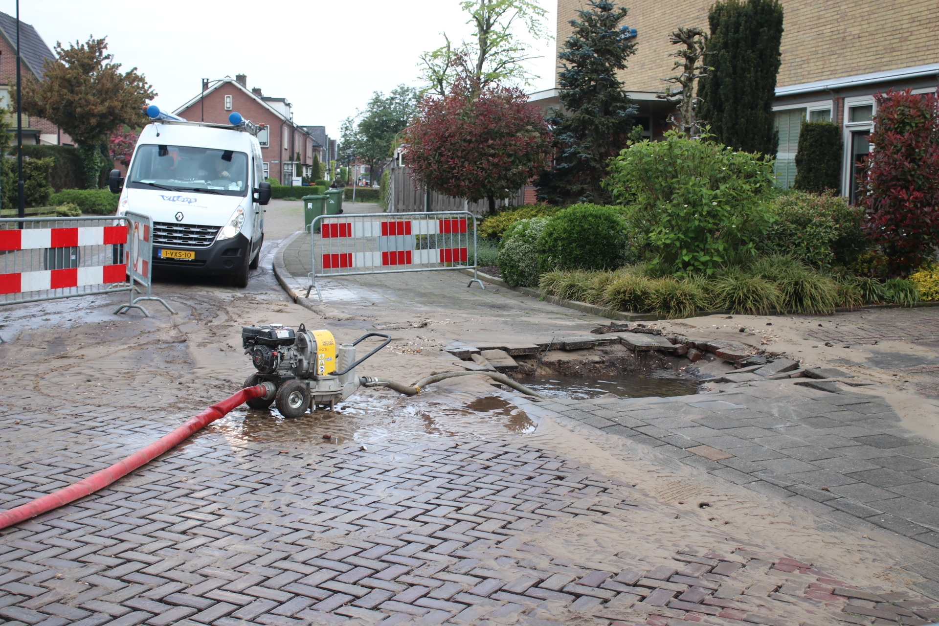 Groot gat in stoep door gesprongen waterleiding