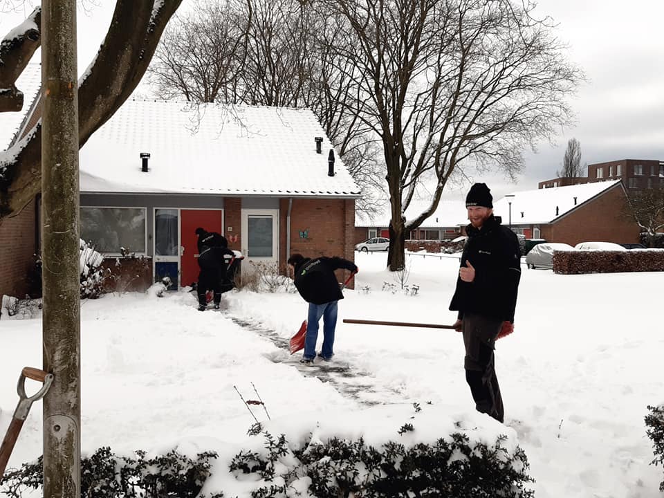 Jongeren die zijn vastgelopen helpen ouderen om hun oprit sneeuwvrij te maken