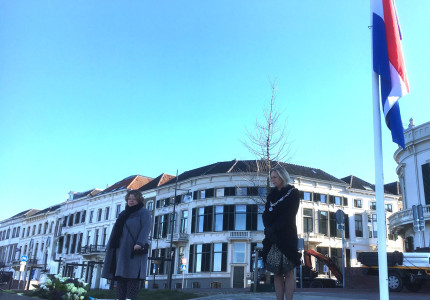 Burgemeester en directeur de Bongerd leggen bloemen bij monument op de IJsselkade