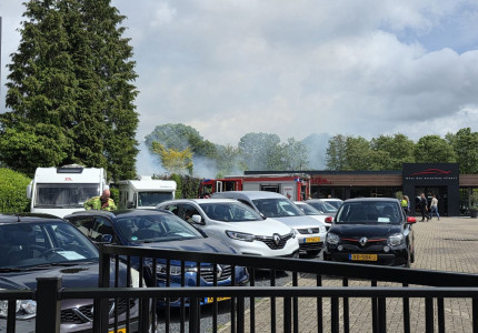 Coniferenheg in brand bij autobedrijf in Apeldoorn