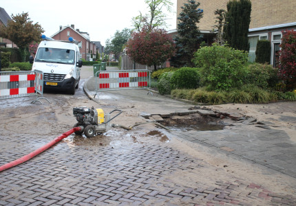 Groot gat in stoep door gesprongen waterleiding
