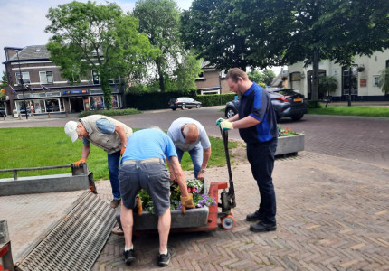 Vrijwilligers plaatsen bloembakken op Marktplein in Brummen