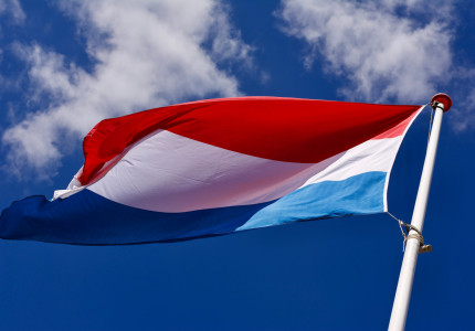 Geslaagde leerlingen hangen de vlag uit tijdens vlaggendag