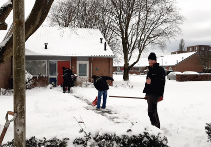 Jongeren die zijn vastgelopen helpen ouderen om hun oprit sneeuwvrij te maken